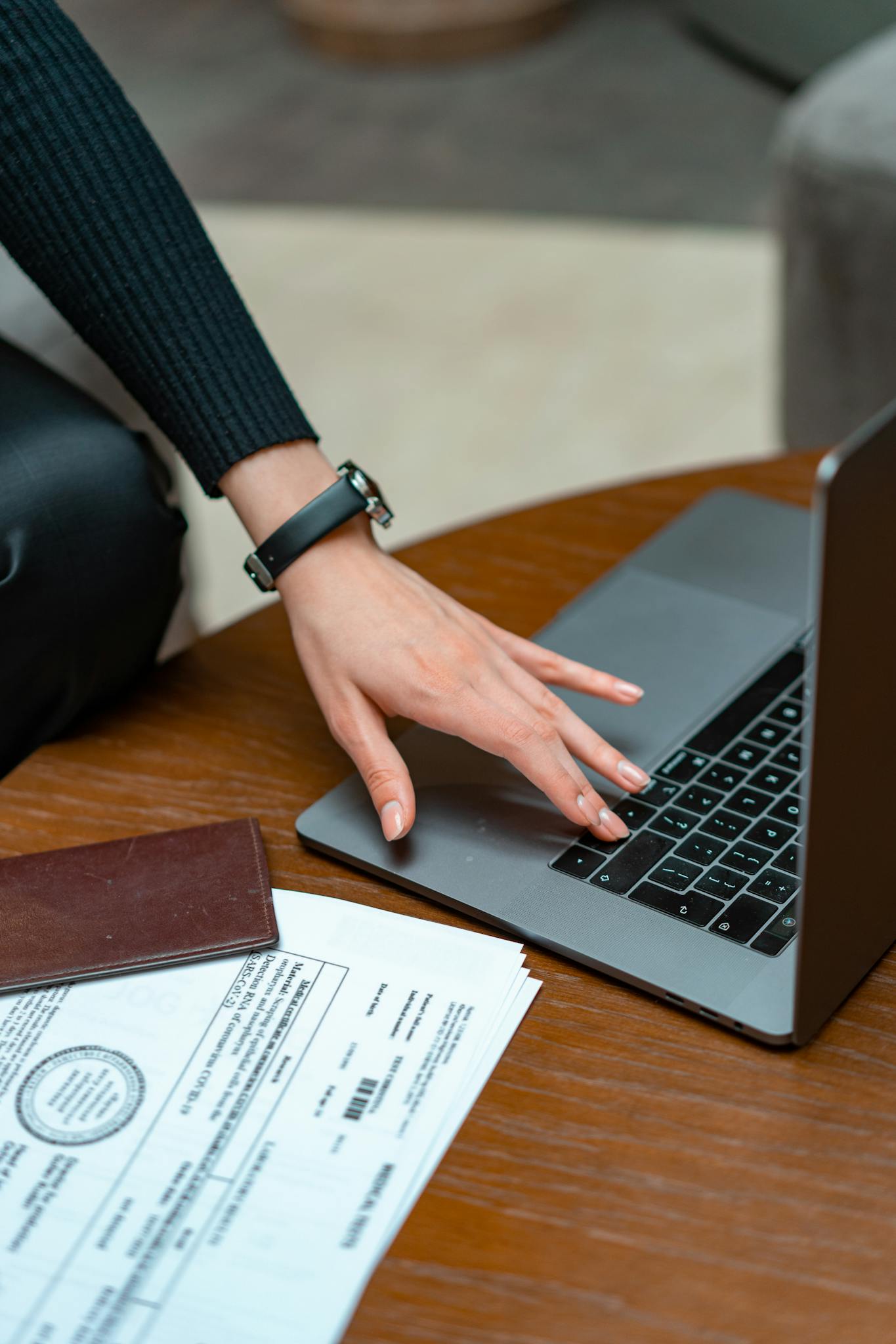 Close-up of a person typing on a laptop with legal documents on a table, showcasing work and technology integration.